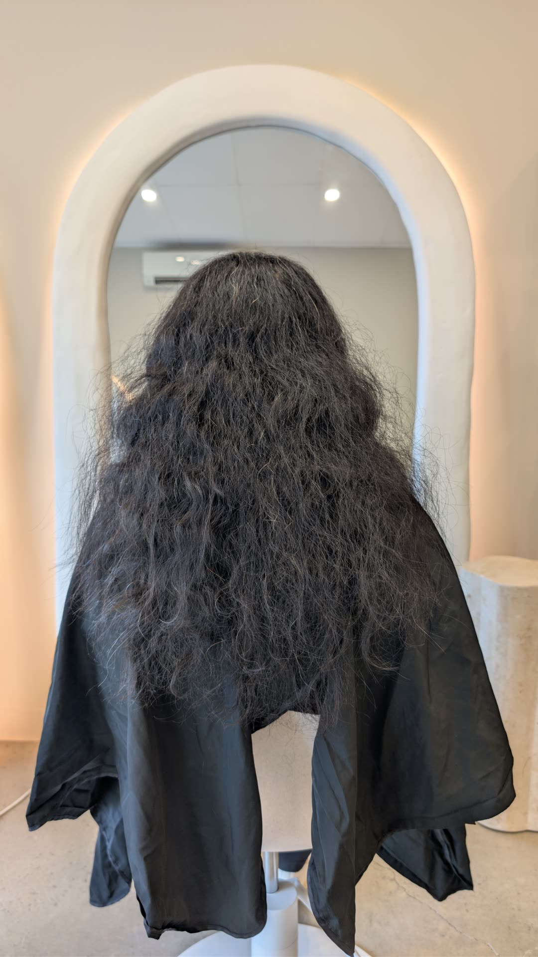 Dark curly hair with frizz before nanoplasty treatment